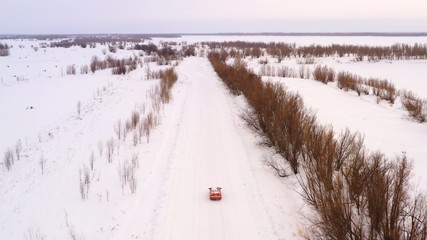 Car rides on a winter snowy road, top view.