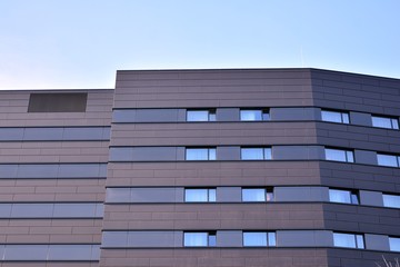A view at a straight facade of a modern building with a dark grey facade.