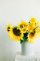 Obraz premium bouquet of bright yellow sunflower flowers in a retro vase on a white background