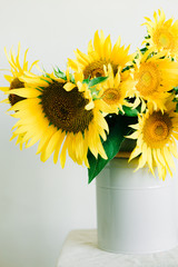 bouquet of bright yellow sunflower flowers in a retro vase on a white background