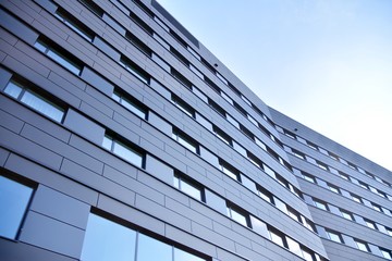Fototapeta na wymiar A view at a straight facade of a modern building with a dark grey facade.
