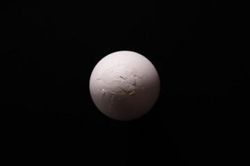 Broken eggs top view on black background