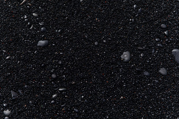 view of black sand and black stones on a beach in Iceland