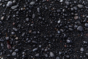 view of black sand and black stones on a beach in Iceland