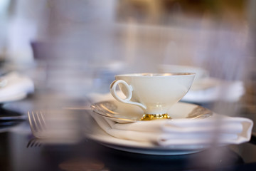 a white tea cup with a gold border is on the table
