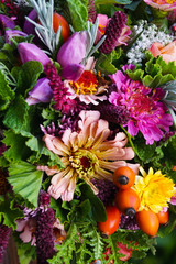 Closeup of colorful bouquet of fresh garden flowers, herbs, scented geraniums, and rose hips