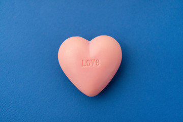 Fototapeta premium Top view composition of pink heart on colorful background. Romantic relationship concept. Romantic Valentines Mother's Day Charity concept. Greeting card poster template with copy space.