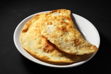 traditional Russian chebureks on a dark background close-up