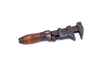 Vintage antique rusty plumber monkey wrench with wooden handle on white background