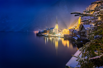 Obraz premium Bick auf das winterliche Hallstatt am Abend mit Schnee und warmer Beleuchtung, Österreich