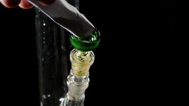 In glass Bong pour cannabis.A twisted piece of paper is dispensed marijuana.
