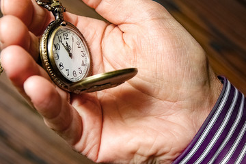 a pocket watch in the hands of a man