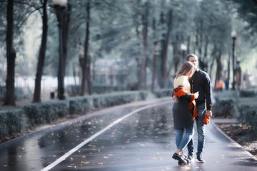 autumn landscape with people in the park / gerfrend and boyfriend hug in autumn park, fall view person