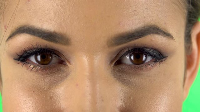 Woman looking straight, smiling and raises an eyebrow flirting. Close up