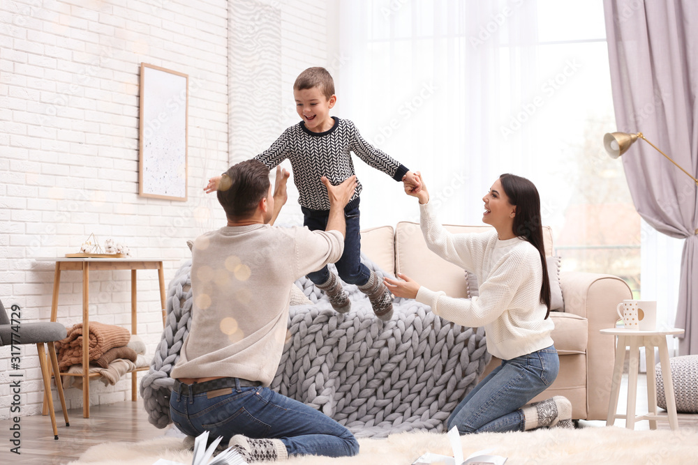 Wall mural Happy family with little son having fun at home. Winter vacation