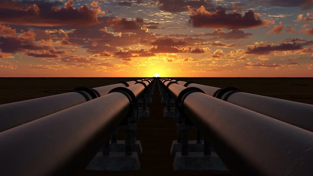 Pipeline transportation of oil, natural gas or water through metal pipes. Concept of the oil refining industry. The camera moves over four pipeline streams right at sunset. 4k Ultra HD 3840x2160