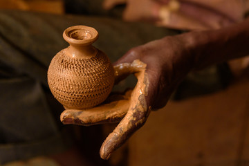 Indian potter making clay pots on pottery wheel in Pottery town is old place. Bangalore. India
