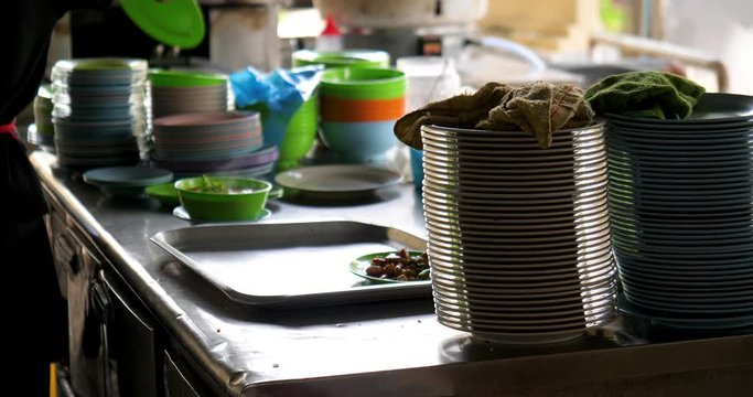 Pile Of Plates And Bowls Stacked On Restaurant Kitchen Steel Table Chef Putting Soup And Orders On A Tray On Kitchen Table Malaysian Typical Restaurant Kitchen 