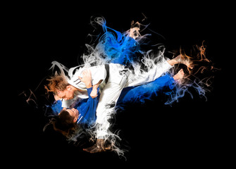 The two judokas fighters fighting men on smoke background