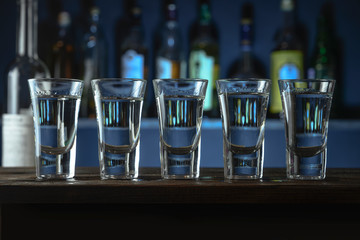 on the bar stand are glasses with alcohol