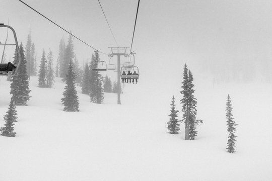 Skiers on chairlift in blizzard