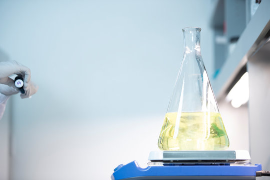Yellow liquid spinning in Erlenmeyer flask on an orbital shaker