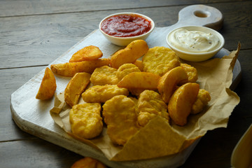 on a white board are chicken nuggets and fried potatoes