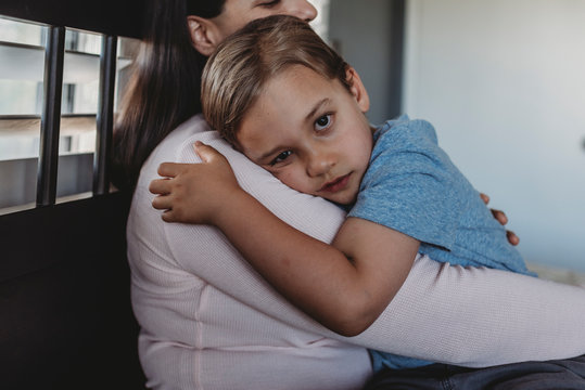 Loving mom cuddling 5 yr old son with big brown eyes