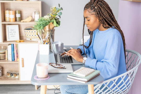 Young girl writing and working with the computer at home