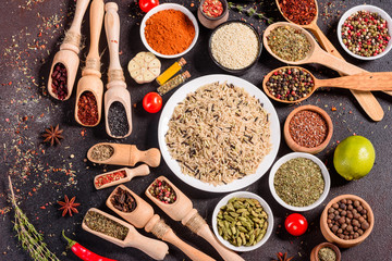 Spices and herbs over black stone background. Top view with free space for menu or recipes