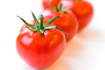 Four delicious ripe red tomatoes on white background. Side angle view. Healthy and organic food concept. Agriculture and harvesting. Vegetable store in supermarket. Illustration for price tag.