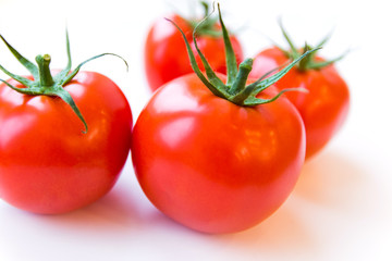 Four delicious ripe red tomatoes on white background. Side angle view. Healthy and organic food concept. Agriculture and harvesting. Vegetable store in supermarket. Illustration for price tag.