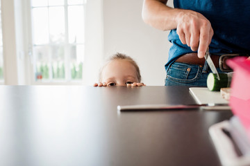 father making a packed lunch for school whilst his daughter watches