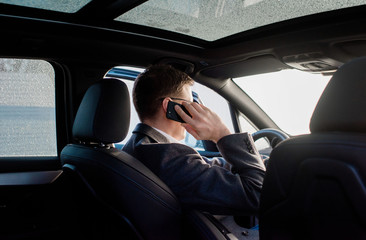 businessman talking on the phone in his frosty car at home