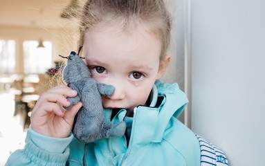 young school girl crying holding her toy looking sad