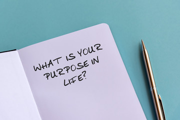 What is your purpose in life? text on note pad on top of wood desk