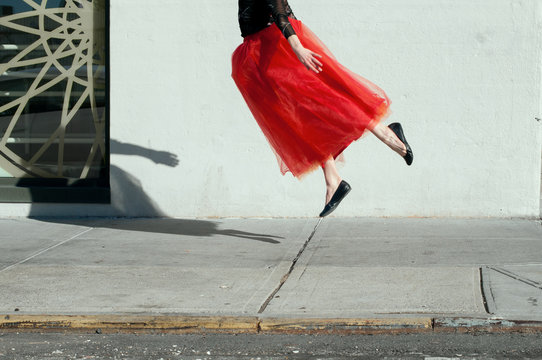 Woman with red skirt in mid-air