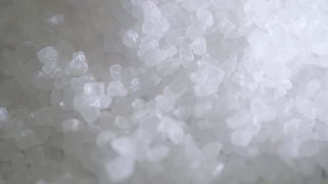Close up of sea salt. Sea salt pouring in slow motion.