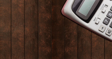 gray big calculator isolated on wooden background