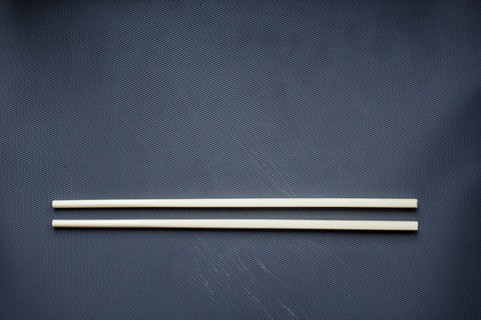 Isolated white chopsticks on a dark blue background