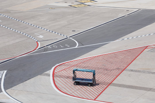 High Angle View Of Empty Baggage Cart On Runway At Airport