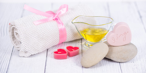 Obraz na płótnie Canvas Banner Spa concept for Valentine's Day. Candles, soap in the form of a heart with text I love you, stones, massage oil and a towel on a wooden background. Relaxation and wellness care. Bath procedure.