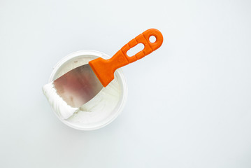 Filler putty in the bucket, White Plaster and spatula. Repair Construction Design Concept