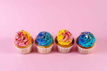 sweet colorful cupcakes on pink background