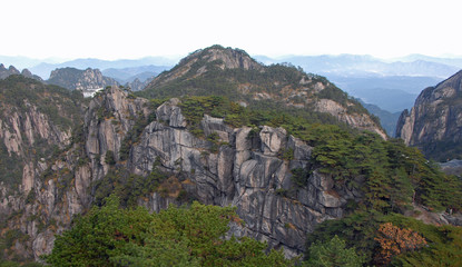 Huangshan Mountain in Anhui Province, China. View of the mountain with peaks, cliffs and pine trees as seen from Flying-Over Rock or Feilai Stone. Scenic view on Huangshan Mountain, China.