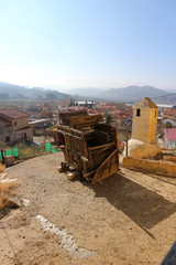 Wooden vintage grain thresher with spanish village on the background