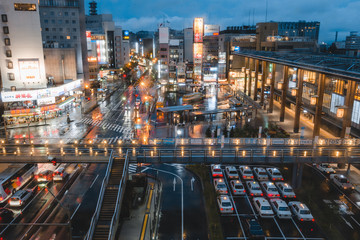 Japanese city during rainey night with vibrant glowing lights and reflections on the road