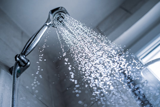 Water running from shower head and faucet in the bathroom,
