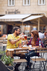 Couple holding cups of  beer and cheering for their love.