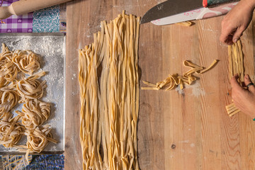 Preparing Fresh Fettuccine Pasta on a wooden table in an Italian Home on a sunday morning